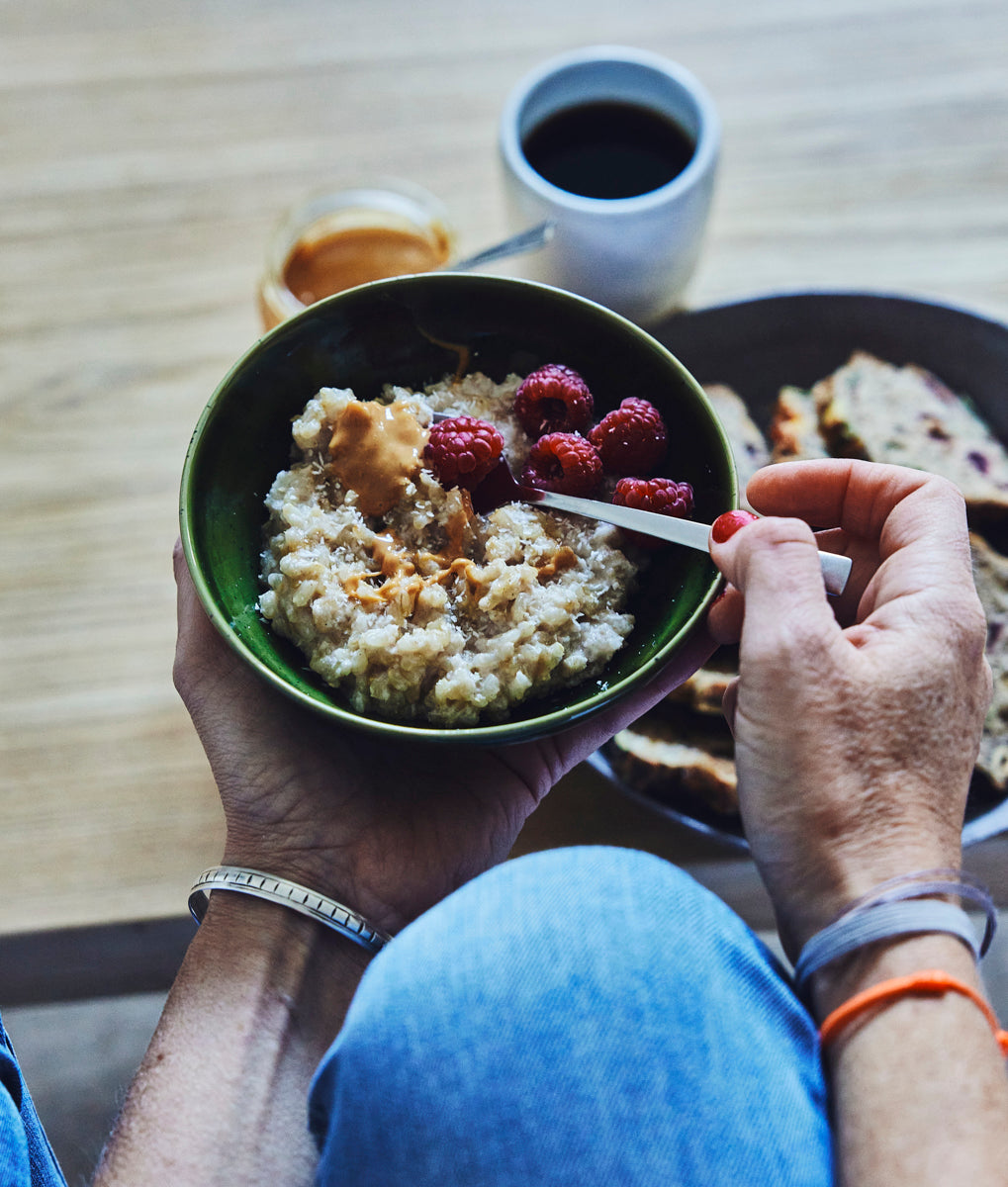 Petit-déjeuner tenu dans les mains, bol aux framboises et café