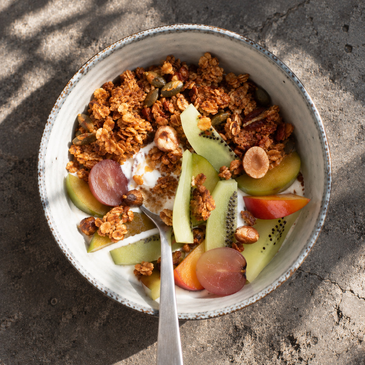 Bol de granola, yaourt, kiwis et fruits frais